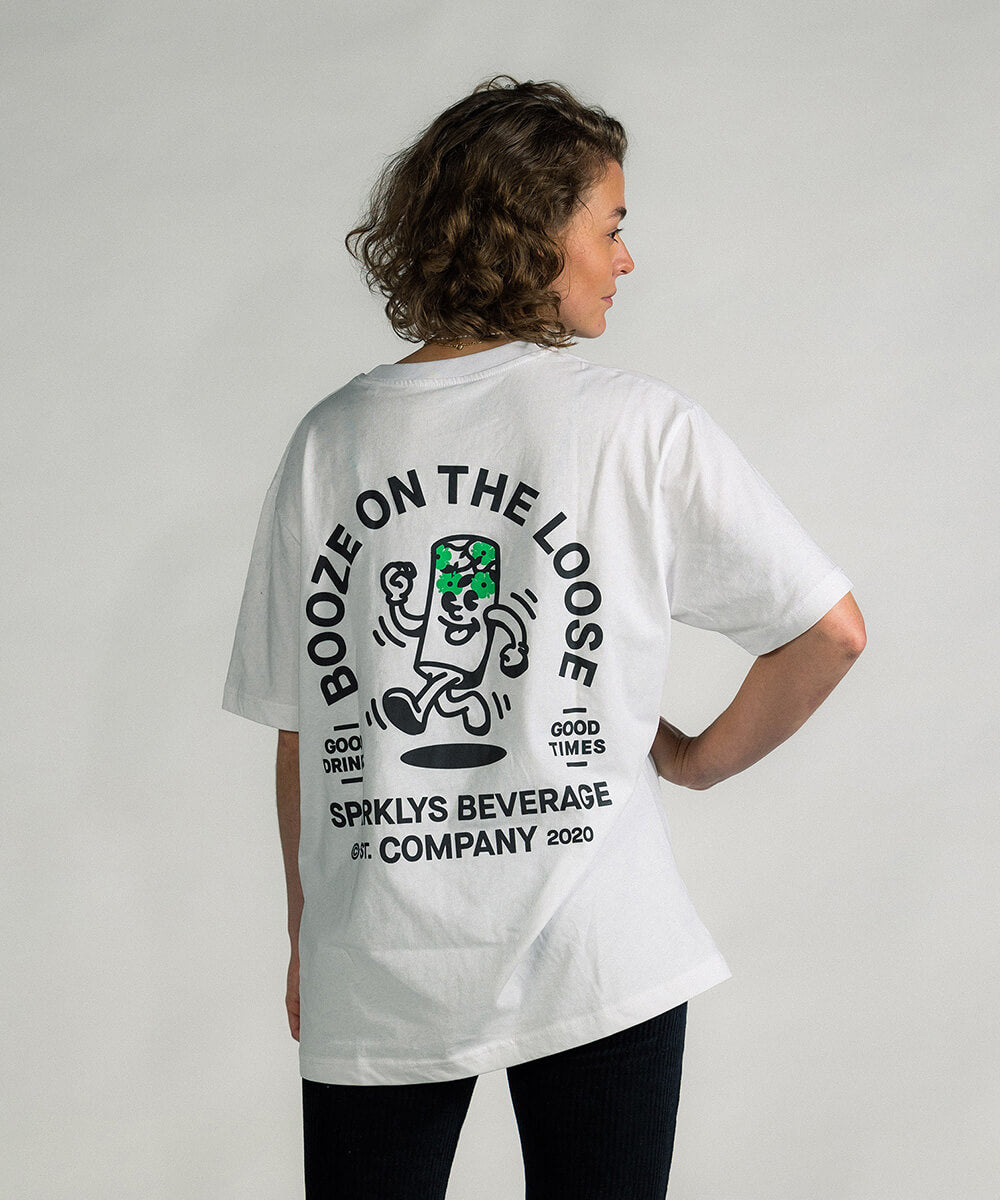 Weibliches Model trägt das weisse Baumwoll-T-Shirt von Sparklys, zeigt die künstlerische Rückseite mit dem Vintage-Comic-Design von 'Booze on the loose'.