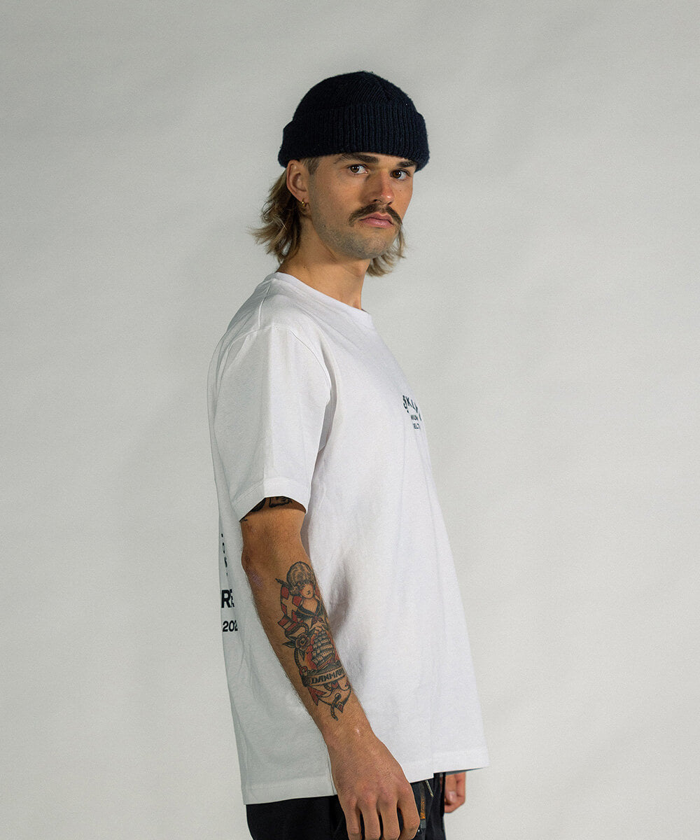 Männliches Model in Seitenansicht, trägt das weisse Baumwoll-T-Shirt von Sparklys, bietet einen Blick auf das Seitenprofil des Shirts.